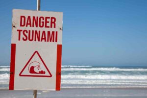 Una spiaggia e il cartello danger tsunami