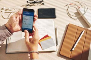 Persona controlla il conto in banca con lo smartphone