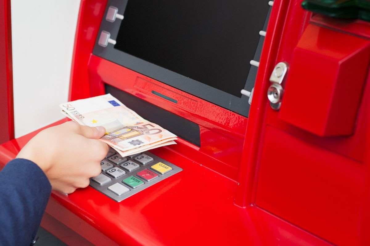persona che preleva al bancomat 50 euro