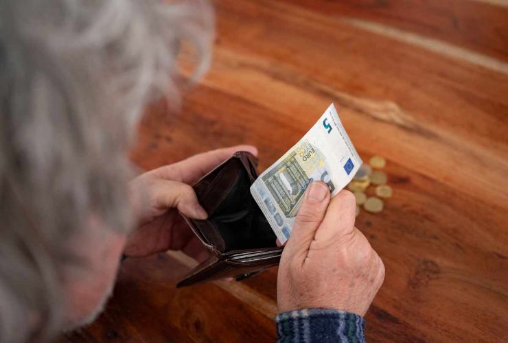 anziana prende banconota da 5 euro nel portafoglio