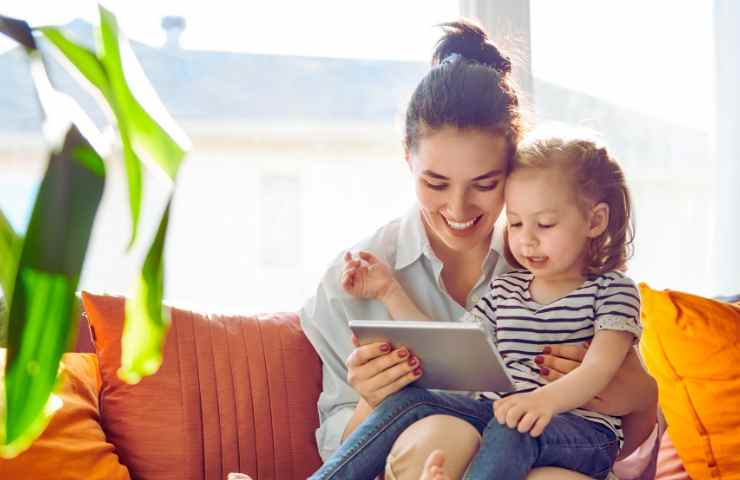 mamma e figlia piccola guardano tablet