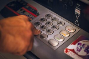 uomo digita tastiera bancomat