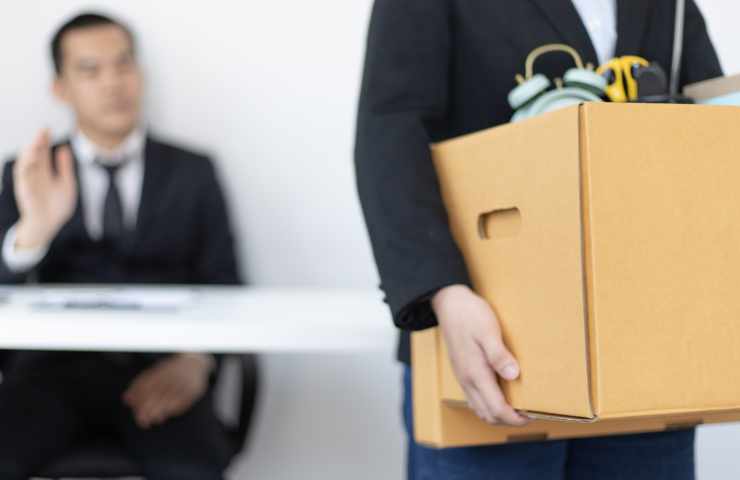 persona esce di stanza con scatola in mano