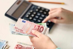 persona con calcolatrice e banconote euro