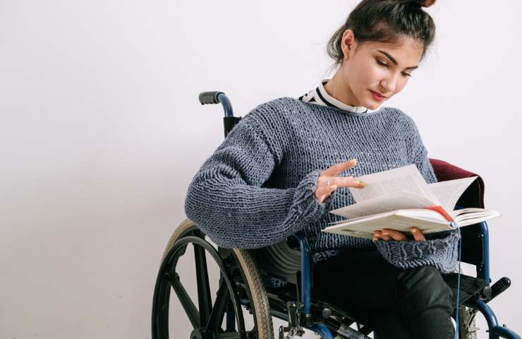 ragazza in carrozzina legge libro