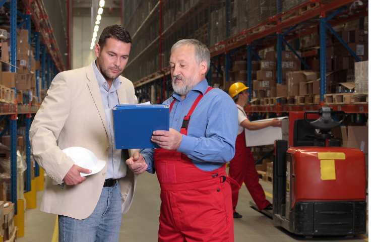 lavoraore anziano e uomo guardano documento