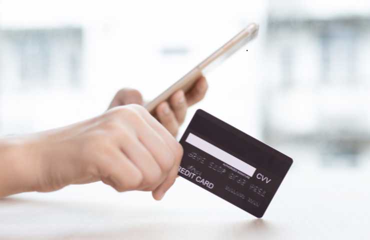 persona con bancomat in mano